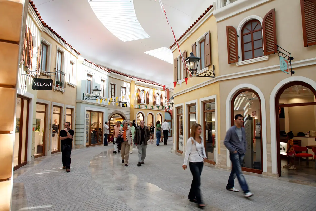 Menschen flanieren durch eine wie eine mediterrane Altstadt gestaltete überdachte Einkaufspassage in Bremerhaven.