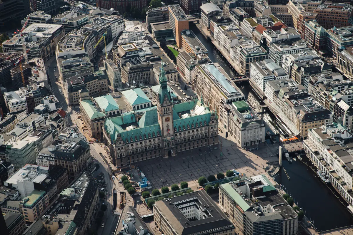 Vogelperspektive auf das Hamburger Rathaus mit auffälligem grünem Kupferdach und den weitläufigen Rathausmarkt in Hamburg.