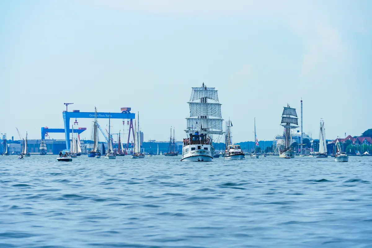 Zahlreiche Großsegler und Boote fahren bei der Windjammerparade auf dem Wasser in Kiel.