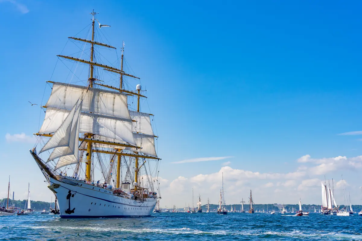 Das weiße Dreimast-Segelschiff Gorch Fock zieht mit gesetzten Segeln über das Wasser bei der Windjammerparade in Kiel.