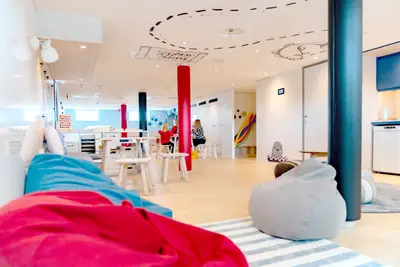 Heller, moderner Kids Club an Bord der A-ROSA Sena mit Spielbereich, bunten Sitzsäcken und spielerischen Deckendekorationen für Familien.