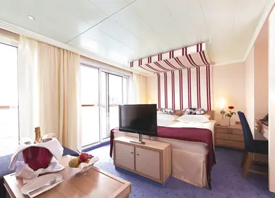 Geräumige Suite mit Doppelbett, Sitzbereich, Balkon und Willkommens-Champagner an Bord der A-ROSA SILVA.