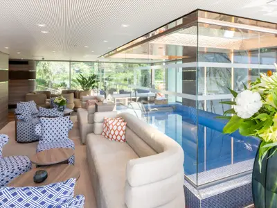 Moderne Lounge auf der Amadeus Amara mit bequemen Sitzbereichen, grossen Fenstern und einem durch Glaswände abgetrennten Innenpool.