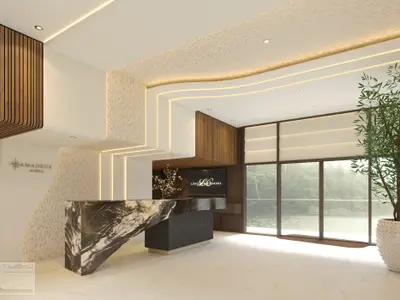 Moderne Kreuzfahrtschiff-Lobby auf der Amadeus Aurea mit Marmor-Rezeptionstresen, Holzvertäfelung und indirekter Beleuchtung. Große Fenster bieten Blick auf einen Fluss und üppige Vegetation. Ein großes grünes Gewächs im Vordergrund. 