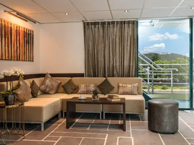 Eckcouch auf der Amadeus Brilliant mit Couchtisch und Panoramablick auf Fluss und bewaldete Berge durch großes Fenster.