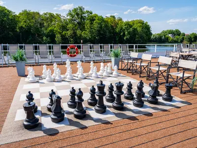 Das Sonnendeck der AMADEUS Diamond an einem sonnigen Tag. Im Vordergrund ein großes Schachspiel mit schwarzen und weißen Figuren. 