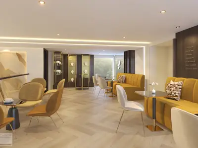 Helle und elegante Innenlounge eines Kreuzfahrtschiffes. Zahlreiche gelbe Sessel und Sofas mit kleinen Tischen stehen auf einem hellen Fischgrätparkett. Im Hintergrund sind verglaste Vitrinen mit Schmuckauslagen zu sehen. Eine große Fensterfront zeigt grüne Natur.