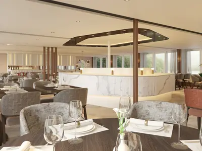 Ein modernes und elegantes Restaurant auf der AMADEUS Mira mit vielen gedeckten Tischen, bequemen Stühlen, einer langen Marmor-Theke und großen Fenstern mit Blick nach draußen. 