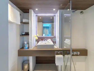 Modernes Badezimmer einer Suite auf der AMADEUS Provence mit Dusche, Waschtisch und Beleuchtung.