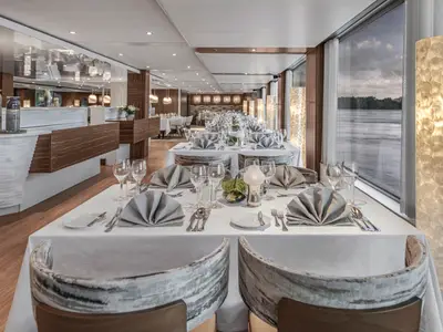 Elegantes Restaurant auf der AMADEUS Queen. Weiss gedeckte Tische sind bereit. Grosse Fenster mit Flussblick. 