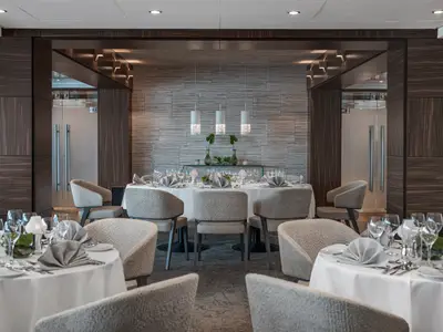 Elegantes Spezialitätenrestaurant auf der AMADEUS Queen mit stilvoll gedeckten Tischen und moderner Einrichtung an Bord.