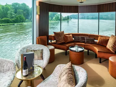 Elegante Lounge auf der AMADEUS Star mit komfortablen Sitzgelegenheiten und Panoramablick auf den Fluss.
