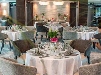 Elegantes Restaurant an Bord der AMADEUS Star mit festlich gedeckten Tischen und bequemen Sesseln.