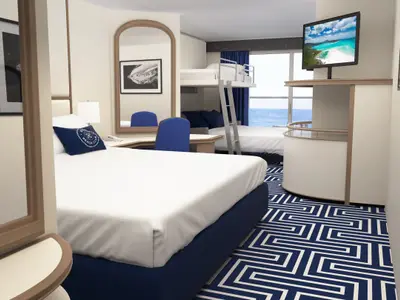 Eine moderne Familienkabine an Bord der Carnival Adventure mit bodentiefen Fenstern, die Meerblick bieten. Die Kabine ist ausgestattet mit einem Doppelbett, Etagenbetten, einem Schreibtisch und einem Flachbildfernseher. Der Boden ist mit einem blau-weißen geometrischen Musterteppich ausgelegt.
