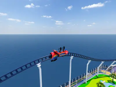 Eine rote, zweisitzige Achterbahn ('BOLT Coaster') fährt auf einem blauen Track hoch über dem Meer auf dem Oberdeck der Carnival Celebration. Blauer Himmel mit weißen Wolken. Im Vordergrund rechts ist ein Minigolfbereich erkennbar.
