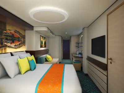Eine modern gestaltete Kreuzfahrtkabine mit einem großen Bett, bunten Kissen, einem orangefarbenen Läufer, einem Sofa, einem Schreibtisch und einem Wandbild mit einem Oldtimer.