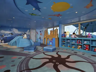 Geräumiger Kinderbereich an Bord der Carnival Freedom mit blauer Unterwasser- und Arktis-Wandgestaltung. Links ein Iglu-Klettergerüst, in der Mitte ein goldenes Schloss und rechts ein Regal voller Spielzeug. Die Decke zeigt bunte Fische, der Boden einen Oktopus. Große Fensterfront mit Blick nach draußen.