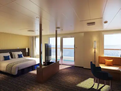 Geräumige, moderne Balkonkabine auf der Carnival Horizon mit einem bequemen Doppelbett, einer Sitzecke und direktem Zugang zu einem privaten Balkon mit Meerblick. Die Kabine ist in warmen Gelb- und Blautönen gehalten.