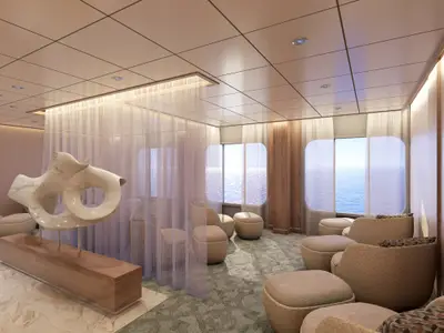 Blick in eine helle, moderne Lounge auf der Carnival Jubilee mit großen runden Fenstern, die den Ozean zeigen. Im Vordergrund steht eine große, abstrakte Skulptur aus hellem Marmor auf einem Holzsockel. Die Lounge ist mit mehreren hellen, gepolsterten Sesseln und Hockern ausgestattet. Ein leichter, weißer Vorhang teilt den Raum, und die Decke hat integrierte Beleuchtung.