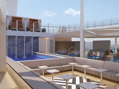 Ein modern gestalteter Poolbereich auf der Carnival Jubilee mit einem langen Pool, blau gefliestem Wasserfall, bequemen Lounge-Möbeln und Teppich mit geometrischen Mustern. Im Hintergrund ist das offene Meer zu sehen.