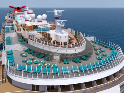 Blick von oben auf das Sonnendeck der modernen Carnival Jubilee, das viele blaue Liegen, runde Loungesessel und offene Decksbereiche am Bug zeigt. Im Hintergrund sind weitere Decks mit Pools und einem Großbildschirm sichtbar. Das Schiff ist auf offenem Meer.