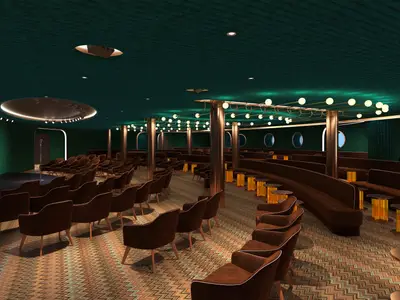 Innenansicht des 'Punchliner Comedy Club'. Grüner Raum mit Bühne, Mikrofon und braunen Sesselreihen. Dazu Lounge-Bänke, Tische, runde Bullaugen und viele Lampen.