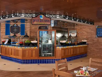 Mexikanisches Buffet 'Blue Iguana Cantina' an Bord. Die Theke ist reichlich mit frischen Zutaten für Tacos und Burritos gefüllt. Dekor mit Holz, blauen Fliesen und Ziegelwänden.