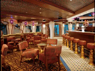 Weitwinkelansicht einer orientalisch gestalteten Bar-Lounge auf der Carnival Miracle mit einer langen Bar, Hockern, Sesseln, Sofas und gemusterten Decken- und Wandelementen.
