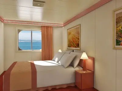 Geräumige Außenkabine der Carnival Splendor mit Doppelbett, Nachttischen, Lampen und einem Fenster mit Blick auf das blaue Meer und eine ferne Küstenlinie. Zwei Bilder zieren die Wände.