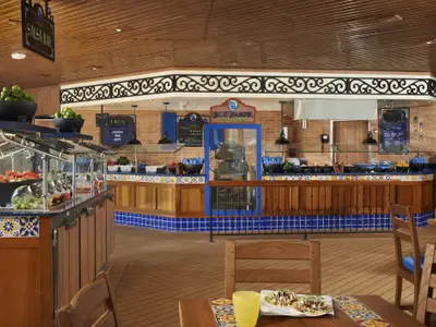 Eine bunte, mexikanisch thematisierte Buffet-Linie auf der Carnival Sunshine, mit frischen Zutaten, Taco-Stationen und hellen Fliesen, ohne Personen.
