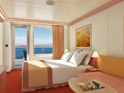 Eine helle, moderne Balkonkabine an Bord der Carnival Valor mit einem Doppelbett, einem kleinen Sofa, Beistelltisch und einer breiten Fensterfront mit Balkontür zum offenen Meer.