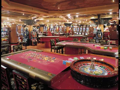 Innenansicht eines luxuriösen Casinos auf der Carnival Valor. Mehrere Roulette-Tische mit Chips und Spielautomaten sind zu sehen. Dekoriert mit zwei detailreichen Samurai-Rüstungen und aufwendiger Holzdecke mit Sternenlichtern.