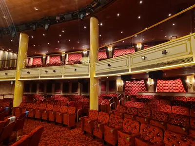 Blick in ein opulentes Theater der Carnival Venezia: Reihen von leeren, roten Samtsitzen und goldene Balkone mit luxuriöser Ausstattung.