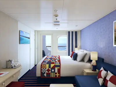 Helle und geräumige Balkonkabine der Carnival Vista. Ein Doppelbett mit maritimem Bettläufer, ein Sofa und ein Balkon mit Meerblick sind zu sehen.