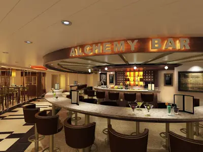 Innenansicht der modernen Alchemy Bar der Carnival Vista. Eine geschwungene Theke mit Hockern und Cocktails. Der beleuchtete Schriftzug 'ALCHEMY BAR' ist zu sehen. Im Hintergrund Tische und eine Bar mit Flaschen und einer Periodentafel.