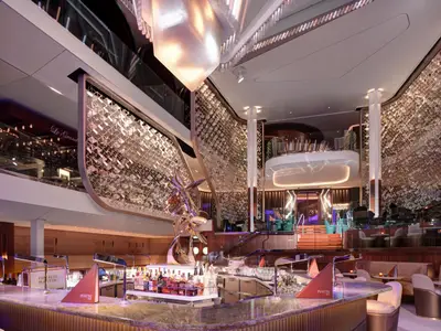 Blick in die luxuriöse, mehrstöckige Martini Bar der Celebrity Ascent. Eine Skulptur, schimmernde Wände und Sitzbereiche.