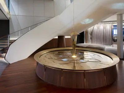 Elegantes Atrium mit geschwungener Treppe und faszinierendem nautischen Kunstwerk.