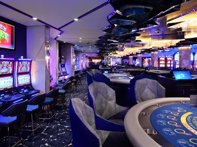 Modernes Casino mit Spielautomaten, Black Jack Tischen und stilvoller Beleuchtung.