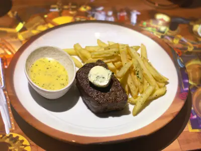 Steak mit Pommes Frites und Sauce in einem Restaurant mit interaktiver Tischprojektion.