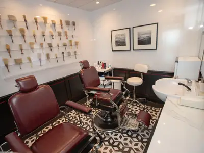 Ein stilvoller Friseursalon oder Barbershop mit zwei Ledersesseln und Rasierpinsel-Deko.