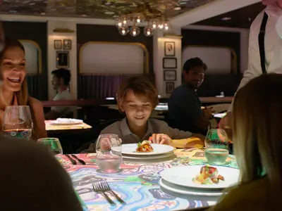 Gäste genießen ein Abendessen in einem Spezialitätenrestaurant mit interaktiven Tischprojektionen.