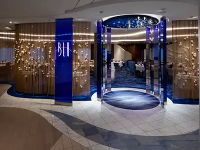 Elegantes Spezialitätenrestaurant in Blau- und Goldtönen mit floralen Elementen und kunstvollem Boden.