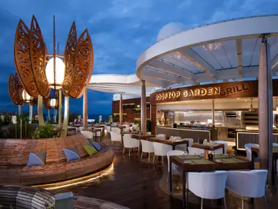 Elegantes Rooftop-Restaurant mit Meerblick bei Abenddämmerung und stilvoller Beleuchtung.