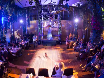 Gäste genießen ein Dinner mit akrobatischen Darbietungen und Live-Musik in einem aufwendig dekorierten Spezialitätenrestaurant.