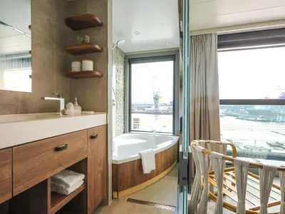 Luxuriöses Badezimmer einer Suite mit Badewanne und Blick auf den Hafen.