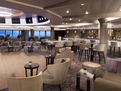 Geräumige und modern eingerichtete Lounge-Bar an Bord der Celebrity Summit. Der Raum bietet vielfältige Sitzgelegenheiten, eine lange Bartheke und Panoramafenster mit Meerblick.