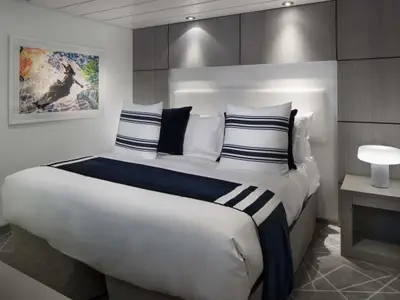 Gemütliche Innenkabine mit Doppelbett, nautischer Dekoration und modernem Nachttisch.