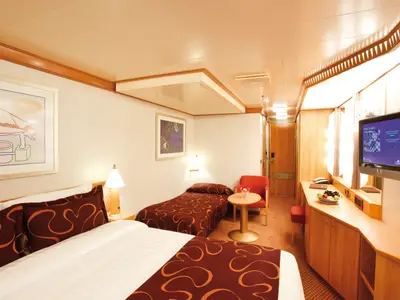 Komfortable Außenkabine an Bord der Costa Deliziosa mit einem Doppelbett, einem Einzelbett, Fernseher und Fenster.