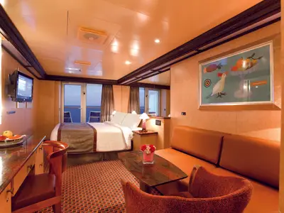 Geräumige Mini-Suite an Bord der Costa Deliziosa mit Doppelbett, gemütlicher Sitzecke, Sofa und Balkonblick auf das blaue Meer.