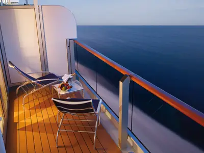 Balkon einer Grand Suite an Bord der Costa Deliziosa mit zwei Liegestühlen, einem Obstteller und weitem Meerblick.